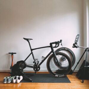 Minimalist indoor cycling setup featuring a sleek road bike and sports equipment for virtual training.