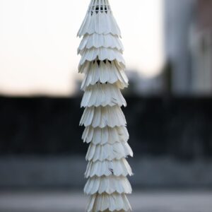 A creative stack of shuttlecocks forming a unique tower in an outdoor setting.