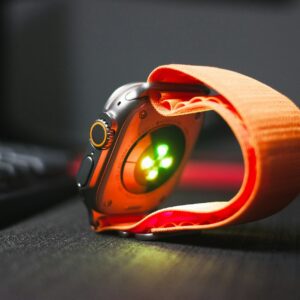 a close up of a watch on a desk near a keyboard