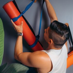 a man holding a yoga mat in his hands
