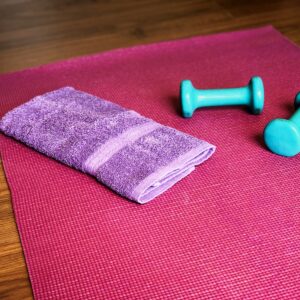Yoga mat, weights, and a towel ready for a workout.